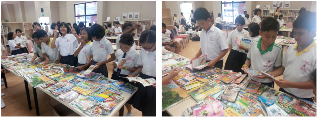 Students in white uniforms browse colorful books spread across tables in a school library.